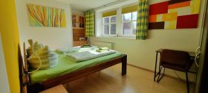 a room with a bed and a chair and a window at dresdnerferienwohnung - apartment am großen garten in Dresden