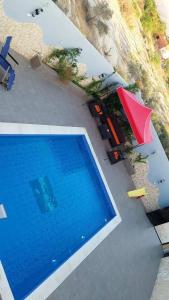 an overhead view of a swimming pool with a red umbrella at مزرعه الوادي in Al Baḩḩāth