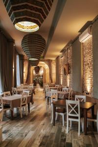 a restaurant with wooden tables and chairs and brick walls at Hotel Piano Kvareli in Kvareli