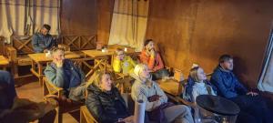 een groep mensen die aan een tafel in een kamer zitten bij Trekker's Lodge 