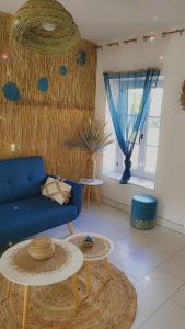 uma sala de estar com um sofá azul e uma mesa em gîte de charèze em Seigy