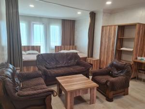 a living room with a couch and chairs and a bed at MikePalace in Batumi
