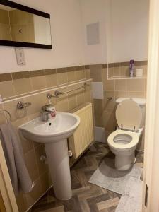 a bathroom with a toilet and a sink at 2 Bed Apartment Sleeps 5, Free Parking, Free Wifi, Spacious, Quiet, Close to Station, Restaurants & Shops, Contractors and Holidays in London