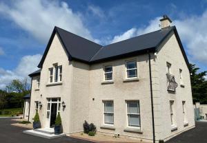 uma casa de tijolos brancos com um telhado preto em Radharc Na Cuilcagh em Enniskillen
