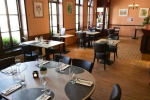 - un restaurant avec des tables et des chaises dans une salle dotée de fenêtres dans l'établissement Le Saint Sébastien, à Blendecques