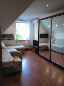 ein Wohnzimmer mit einem Sofa, einem Bett und einem Fenster in der Unterkunft Apartament Mazurska 24a in Kętrzyn