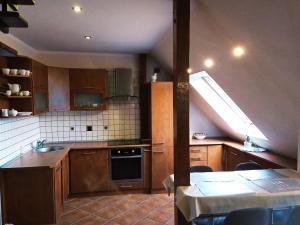 肯琴的住宿－Apartament Mazurska 24a，厨房配有木制橱柜和天窗。