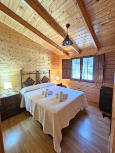 um quarto com uma cama com dois bichos de peluche em La casita de madera Sijuela em Ronda