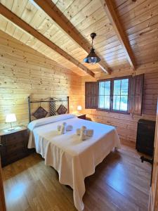 a bedroom with a bed with two stuffed animals on it at La casita de madera Sijuela in Ronda