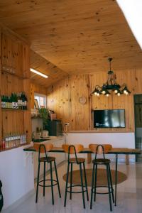 a kitchen with wooden walls and a table with stools at Là Lá La Home in Da Lat