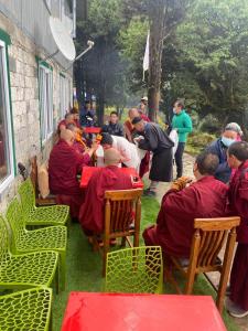 a group of monks sitting at a table in the grass at Trekker's Lodge 