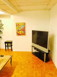- un salon avec une grande télévision à écran plat dans l'établissement Stylish Montreal Apartment: Comfortable Stay in the Golden Square Mile, à Montréal