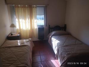 2 camas en una habitación pequeña con ventana en Danimar en San Clemente del Tuyú