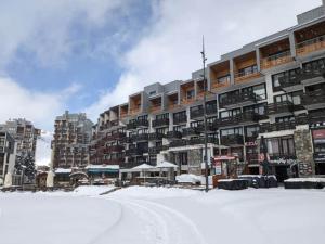 a snow covered street in front of a large building at Duplex ,Tignes Val Claret, pied des pistes in Tignes