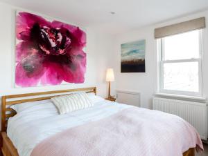 a bedroom with a bed with a flower painting on the wall at Elephant & Oxpecker in Fulham in London