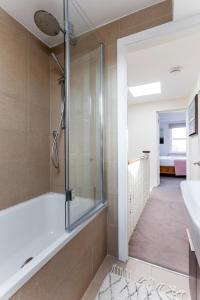 La salle de bains est pourvue d'une douche et d'un lavabo. dans l'établissement Elephant & Oxpecker in Fulham, à Londres