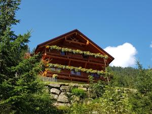 ein Blockhaus mit Blumen auf dem Balkon in der Unterkunft Haus Margreiter in Sankt Leonhard im Pitztal