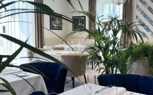 a restaurant with tables and potted plants at Grande Real Villa Itália Hotel & Spa in Cascais