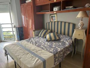 a bedroom with a bed with a blue and white comforter at La ventana al mar in Luanco +6 photos