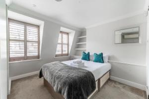 倫敦的住宿－KIN-55 Kinnerton Street，白色卧室配有蓝色枕头的床