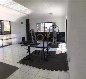 a gym with a treadmill and weights in a room at Apartamento Praia de Ponta Verde com um quarto in Maceió