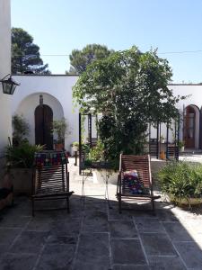 two chairs and a table in a courtyard at Trullo Mauro MGG - Trullo Fragale in Martina Franca