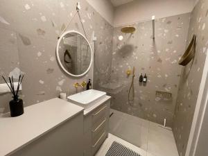 APARTAMENT OVOC GDYNIA NOWE KOLIBKI في غدينيا: حمام مع حوض ومرآة