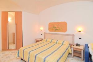 una camera d'albergo con letto e specchio di Oriente Suites e Spa a Ischia