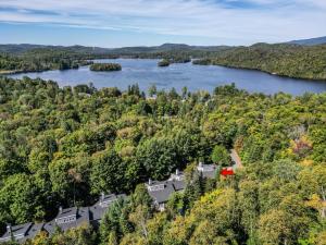an aerial view of a house on a hill next to a lake at The Sunny Paradise in Mont-Tremblant