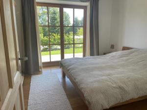 1 dormitorio con cama y ventana grande en Fembacher Alm en Seeon-Seebruck