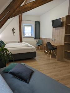 een slaapkamer met een bed, een bureau en een televisie bij Lebererhof Apartments - XL2 in Roßtal