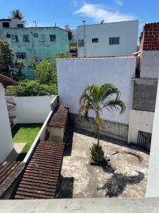 a patio with a palm tree on a building at Hope Hostel Guarapari in Guarapari