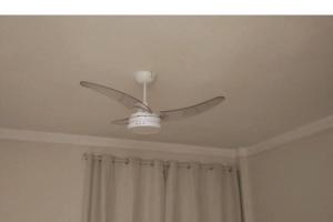 a ceiling fan in a room with a curtain at Studio 1811 Campinas SP in Campinas