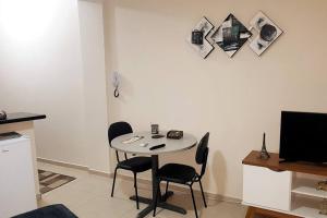 a small table with two chairs and a television in a room at Studio 1811 Campinas SP in Campinas +18 photos