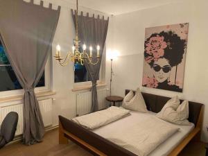 a bedroom with a bed and a chandelier and a window at Seenahes Haus mit Hot Tub in Krumpendorf am Wörthersee