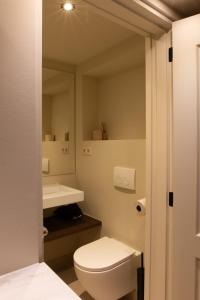 een badkamer met een wit toilet en een wastafel bij B&B Midtown Amsterdam suites in Amsterdam