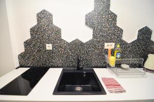 een keuken met een wastafel en een zwart-witte muur bij Old Town Studio Sarajevo in Sarajevo