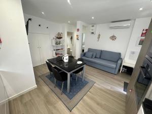 a living room with a table and a blue couch at Ascensor à Vista in Nazaré