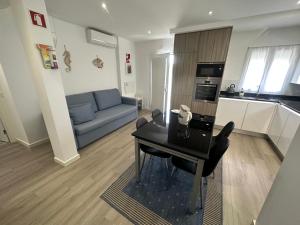 a living room with a table and a blue couch at Ascensor à Vista in Nazaré