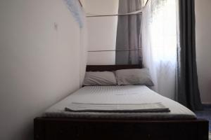 Cama pequeña en habitación con ventana en Roma Airbnb, 
