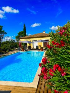a swimming pool in front of a house with flowers at villa Peylon 2 in Flayosc