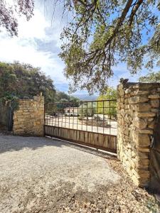 a stone fence and a stone wall with a gate at La casita de madera Sijuela in Ronda