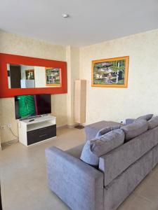 uma sala de estar com um sofá e uma televisão em Edificio Mondrian 1ª Linea vistas al mar em Oropesa del Mar