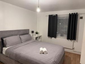een slaapkamer met een bed met twee witte schoenen erop bij Haven 1 in Thamesmead