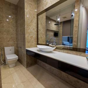 uma casa de banho com um lavatório, um WC e um espelho. em Dorsett Residence walk to Pavilion 1min with Bathtub and infinity pool em Kuala Lumpur