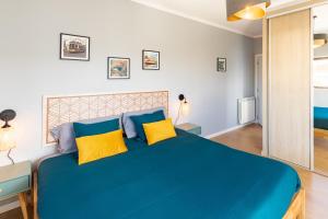 sypialnia z dużym niebieskim łóżkiem z żółtymi poduszkami w obiekcie Modern 3 bedrooms 3 bath apartment 5 minutes walk from the Santuary w Fatimie