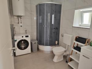 ein Bad mit einer Dusche und einer Waschmaschine in der Unterkunft Una in Krasica