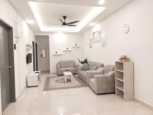 sala de estar con 2 sofás y ventilador de techo en Anis Homestay Nilai en Nilai