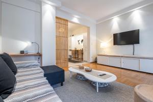 - un salon avec un canapé et une télévision dans l'établissement Alimos Marina Beach Apartment, à Athènes