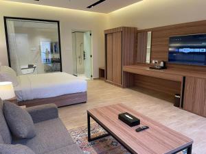 Habitación de hotel con cama y sala de estar. en شاليهات دبليو سويتس الدرب en Qarār